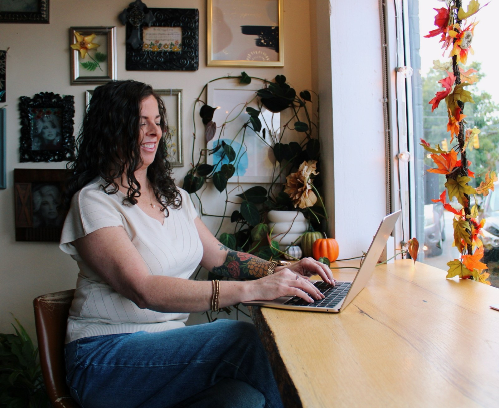 Melissa working at her laptop beside a sunny window